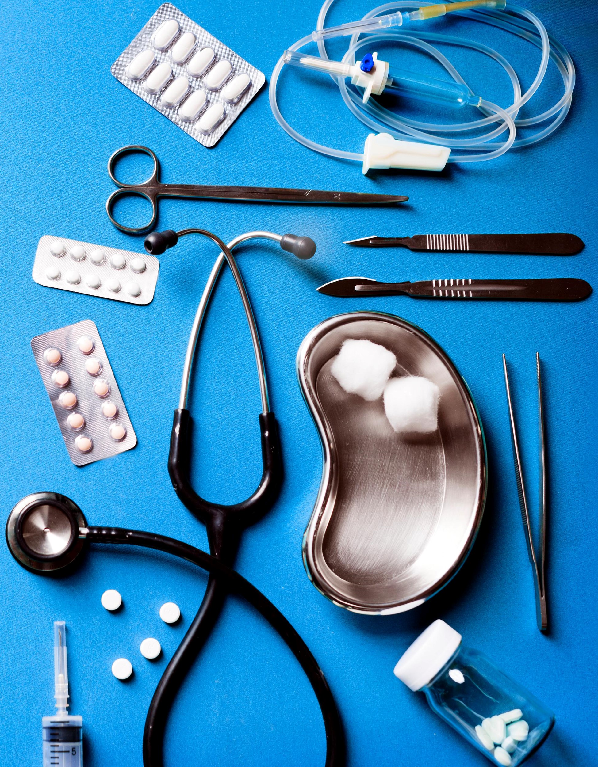 A collection of medical tools and supplies is arranged neatly on a blue surface.