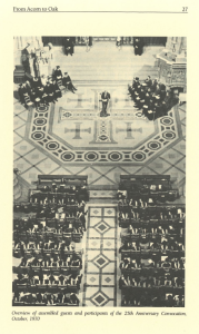 Black and white overhead photo of a formal ceremony showing assembled guests and participants seated in rows, with a speaker at a podium standing on an ornate floor marked by a large cross design. The event took place inside a grand hall or cathedral.