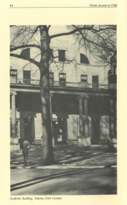 Black and white photo of the Academic Building at Montgomery College’s Takoma Park Campus. A person stands on the sidewalk in front of the columned entrance, with leafless trees casting shadows on the facade.